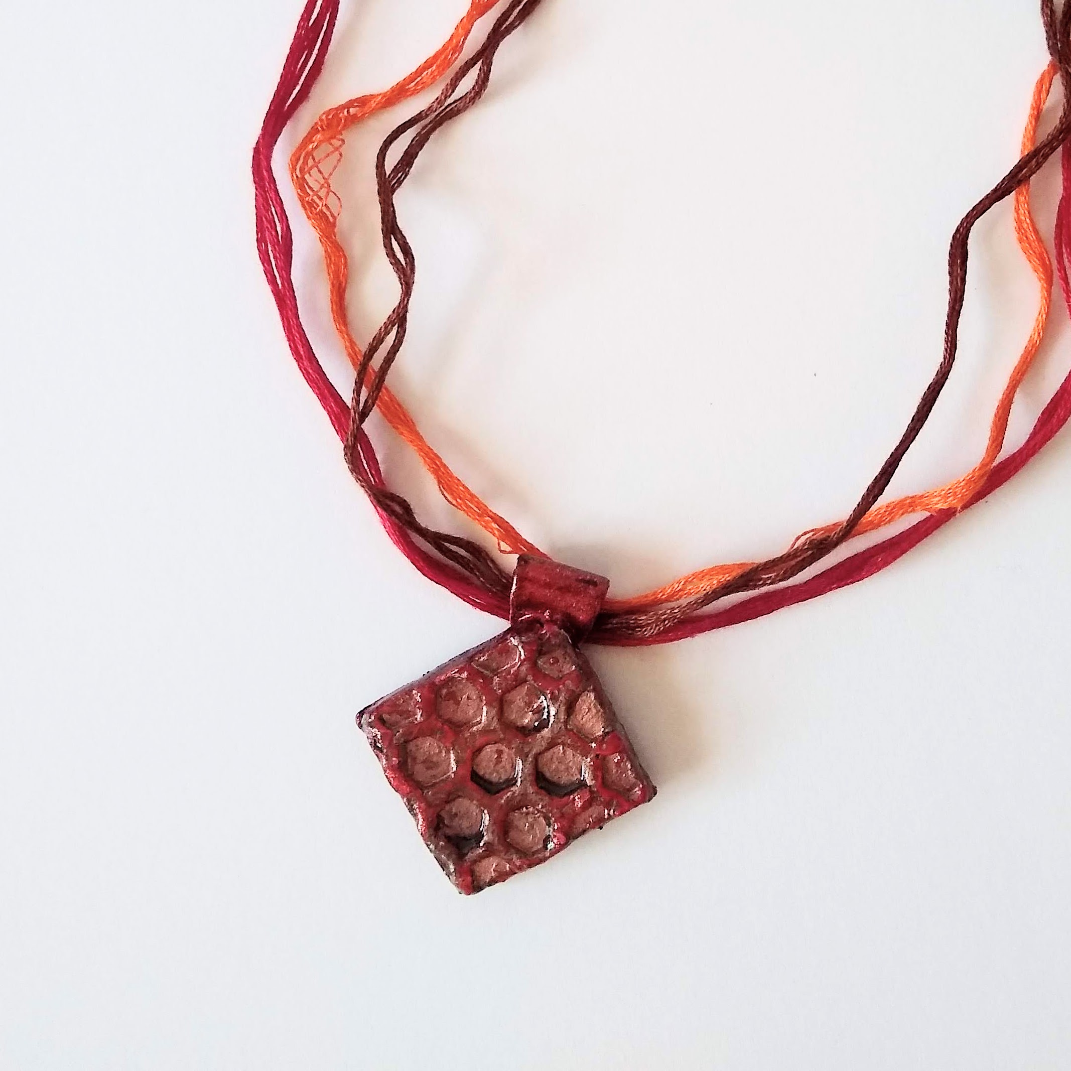 Diamond shape pendant with a honeycomb texture - bronze with deep red highlights - bail in the same material and colours