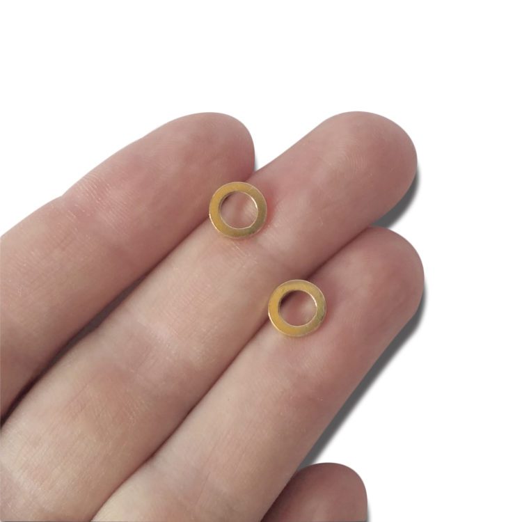 18k yellow gold nought stud earrings - presented on palm of hand for scale