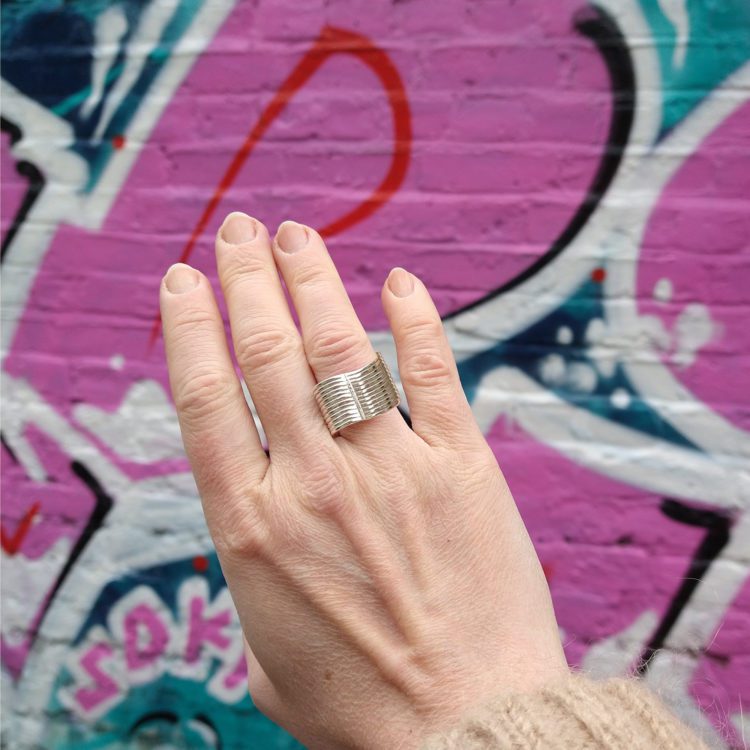 Silver Wave Ring - on model - against street art wall
