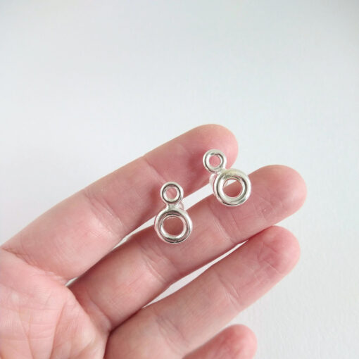Double Torus silver stud earrings by Essemgé - on hand for scale