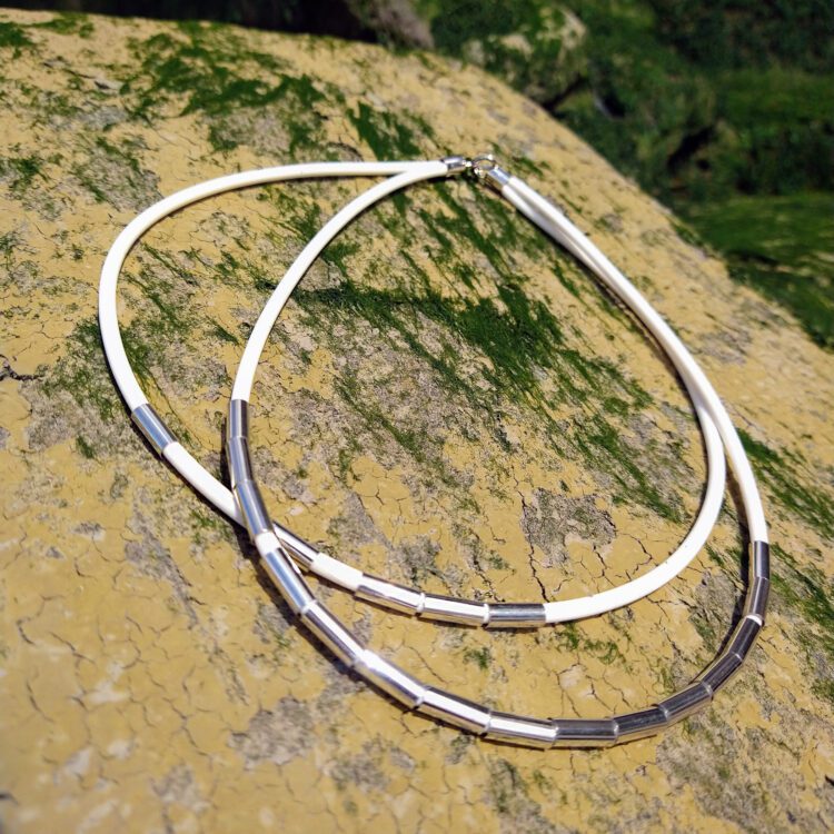 Silver Drape Multirow Necklace by Essemgé - white necklace on rock