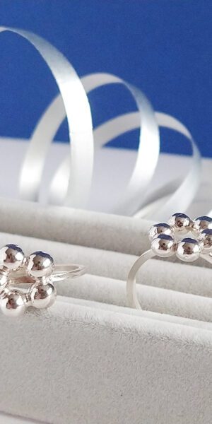 Flower Power Caviar Rings Set by Essemgé - set of 2 silver stacking rings on a grey and blue background
