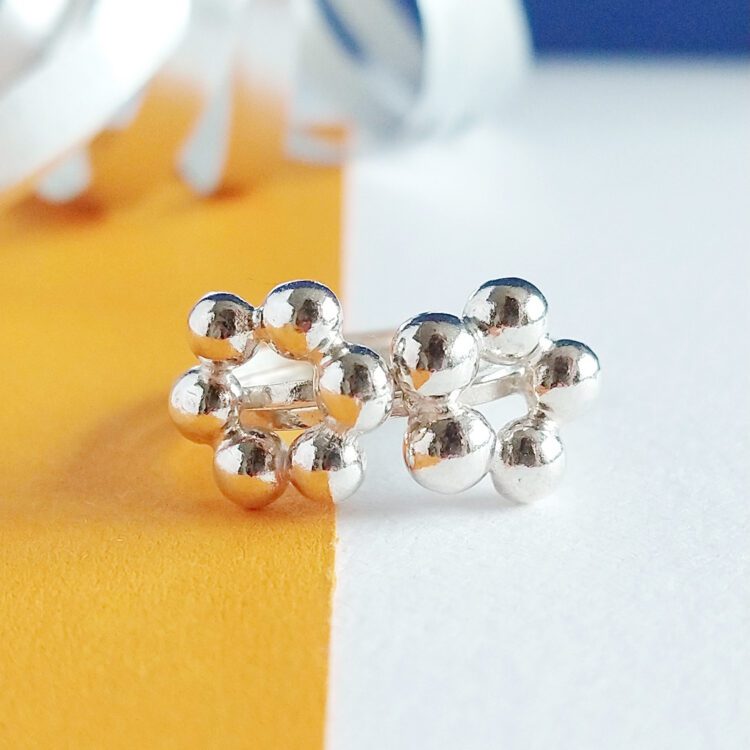 Flower Power Rings Set by Essemgé - set of 2 silver stacking rings on a colourful background