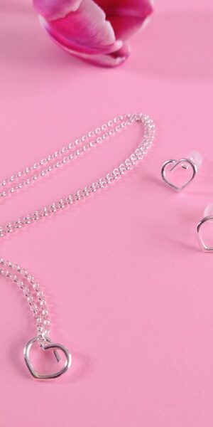 Mini Heart Necklace and Earrings set by Essemgé - silver pendant necklace and matching stud earrings on pink background