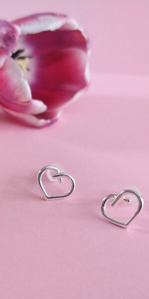 Mini Silver Heart Studs by Essemgé - silver stud earrings in heart shape , on pink background