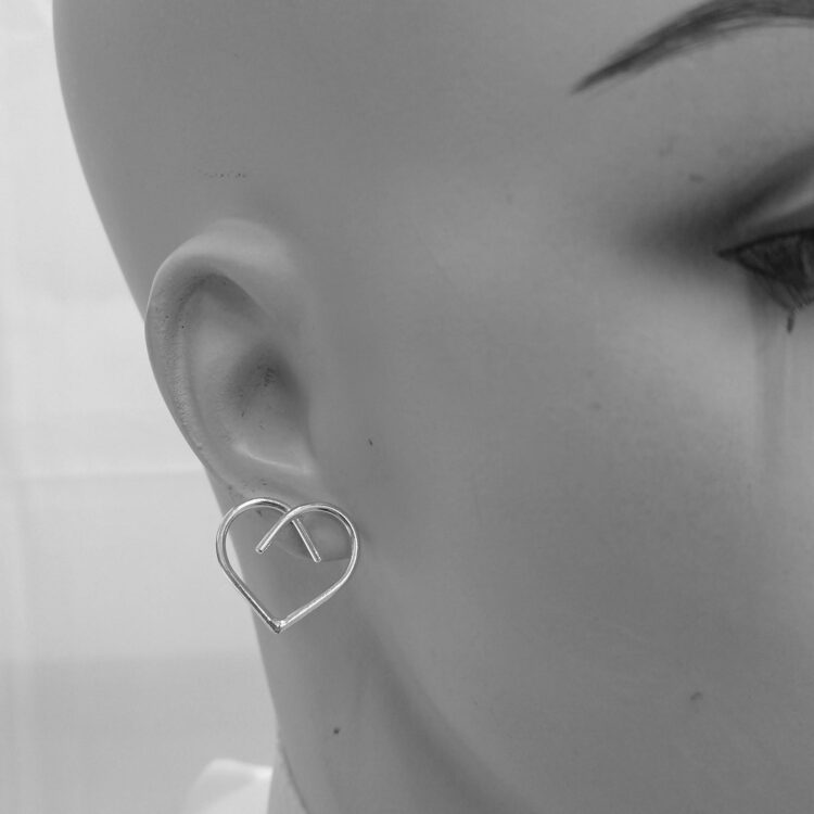 Midi Silver Heart Studs by Essemgé - silver stud earrings in heart shape , on mannequin for scale