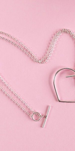 Maxi silver heart pendant necklace by Essemgé - on pink background