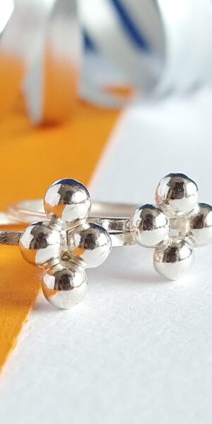 Quatrefoil Caviar Rings Set by Essemgé - 2 stacking silver rings on a colourful background